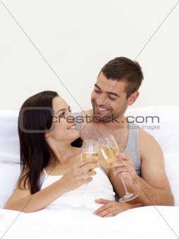 Couple drinking champagne in bed
