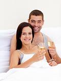 Couple drinking champagne in bed