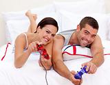 Couple playing videogames in bed