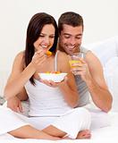 Woman and man having nutritive breakfast in bed