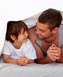 Father and son talking under the bedsheets
