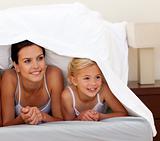 Mother and daughter under the sheets