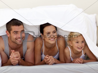 Parents and daughter under the sheets