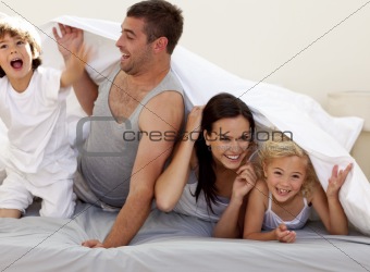Family having fun in parent's bed