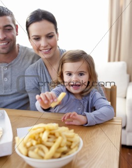 Little girl eating fries at home
