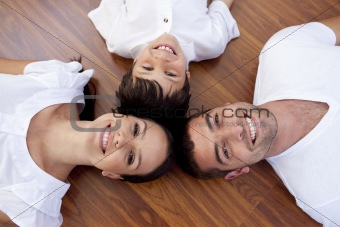Parents and kid lying on floor with heads together