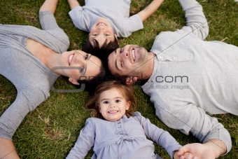 Little girl lying in a park with her parents and brother