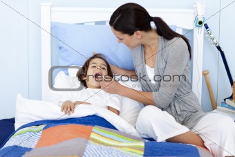 Mother taking her son's temperature with a thermometer
