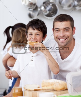 Father and son eating a toast in breakfast time