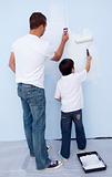 Father and son painting a wall