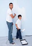 Happy father and son painting a wall