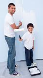 Man and little boy painting a wall