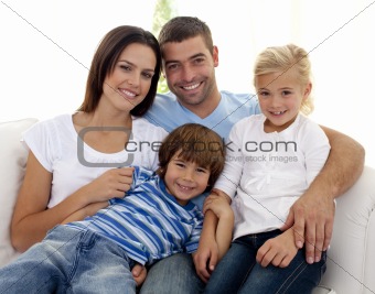 Smiling young family sitting on sofa