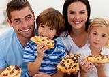 Portrait of family eating pizza in living-room