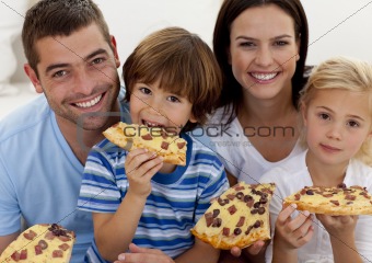 Portrait of family eating pizza in living-room