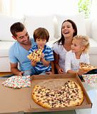 Family eating pizza in living-room