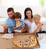 Family eating pizza in living-room