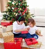 Happy brother and sister looking at Christmas gifts