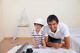 Smiling dad and little boy studying architecture