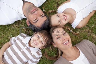 Smiling family lying in a park