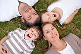 Smiling family lying outdoors