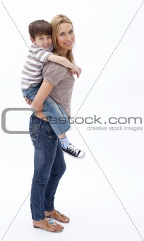Mother giving son piggyback ride against white
