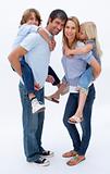 Father and mother giving boy and girl piggyback ride