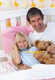 Sick girl playing with a stethoscope with her father