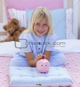 Little girl saving money in a piggy bank