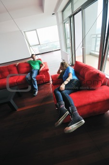 happy couple relax on red sofa 
