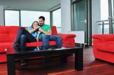 happy couple relax on red sofa 