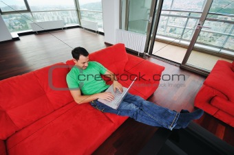 man relaxing on sofa and work on laptop computer
