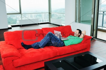 man relaxing on sofa and work on laptop computer