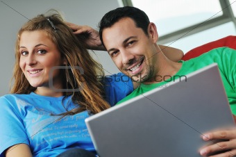 happy couple have fun and work on laptop at home