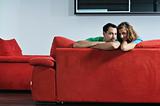 happy couple relax on red sofa