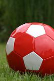 Red soccer ball on grass