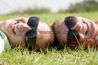 Happy young couple smiling on a lawn