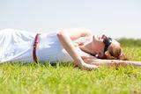 happy young woman laying on a grass field