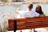 young couple seated at the wooden bench
