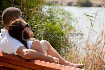 Couple sitting at the wooden bench 