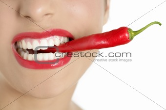 Beautiful woman teeth eating red pepper