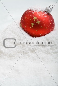 Red christmas bauble in the snow