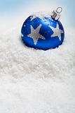 Blue christmas bauble in the snow