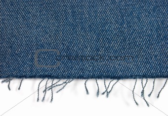 Edge of blue jeans fabric with fringe