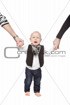 Young baby holding hands with his parents