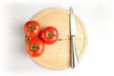 Tomatos and knife on plate