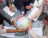 High angle of business team holding a terrestrial globe