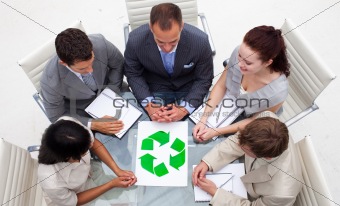 High angle of business team looking at a recycling symbol
