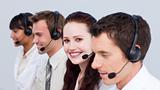 Smiling woman working in a call center with her colleagues