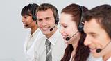 Smiling man working in a call center with his colleagues